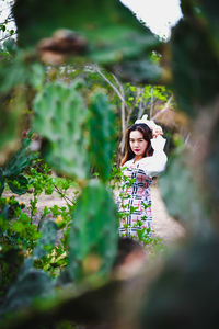 Portrait of woman standing by plants