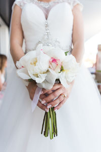 Midsection of woman holding flower bouquet