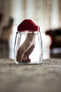 Digital composite of cropped hand in jar