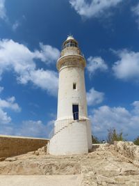 Lighthouse by sea against sky