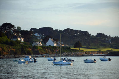 Boats sailing in lake against sky