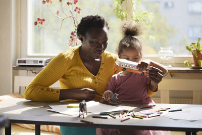 Mother and daughter playing together at table