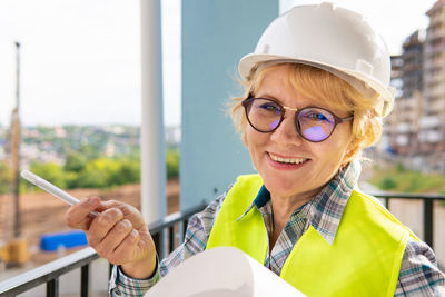 Portrait of smiling woman holding eyeglasses