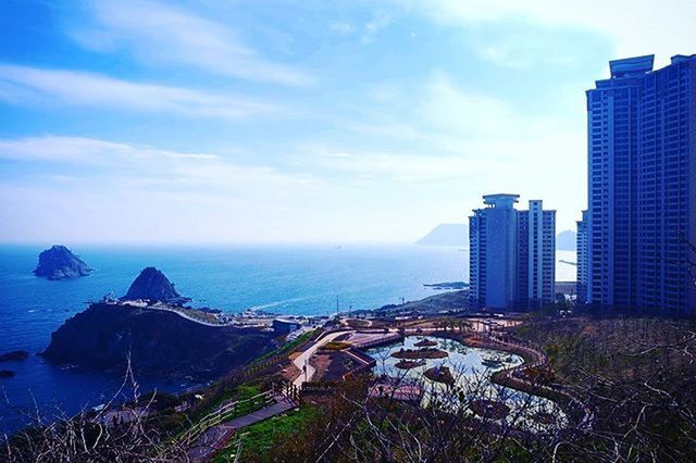 sea, water, sky, building exterior, city, architecture, built structure, cityscape, cloud - sky, horizon over water, blue, scenics, coastline, skyscraper, cloud, nature, high angle view, beauty in nature, beach, outdoors