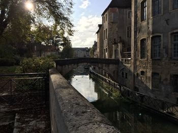 Bridge over canal amidst buildings against sky