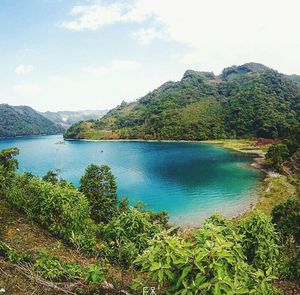 Scenic view of lake and mountains against sky