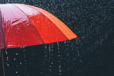 Close-up of wet red umbrella during monsoon