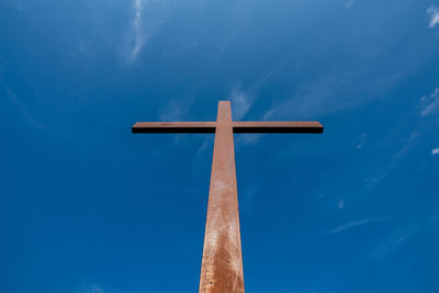 Low angle view of cross against blue sky