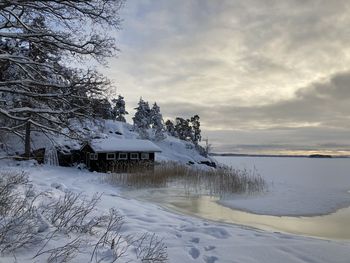 Scenic view of snow covered trees and building against sky