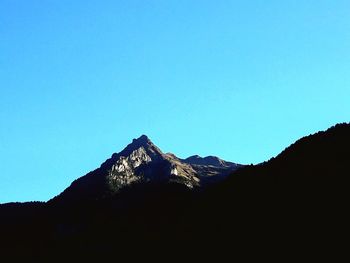 Scenic view of silhouette mountains against clear blue sky