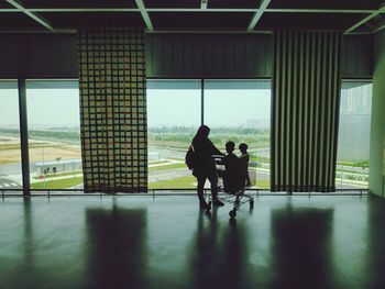 Silhouette men walking in corridor of building