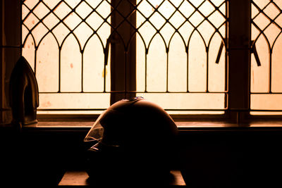 Close-up of crash helmet on stool by window