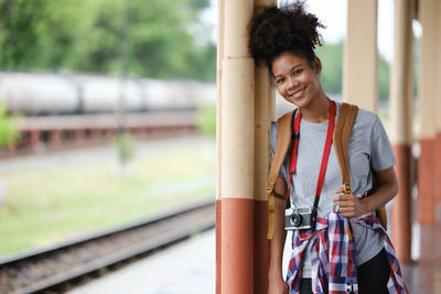 Portrait of young woman standing on railroad track