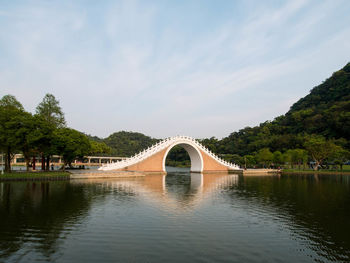 Arch bridge over river against sky