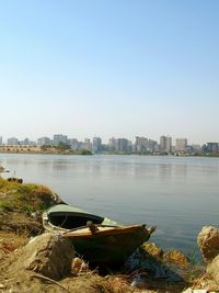 Scenic view of river by buildings against clear sky