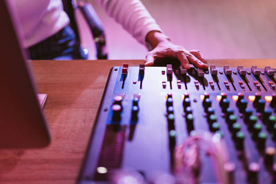 Close up producer woman hands nearby soundboard is mixing, adjusting and editing sounds.