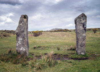 Stone wall on field against sky