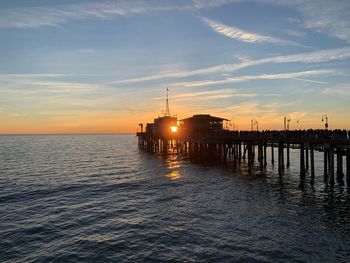 Pier over sea against sky during sunset