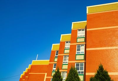 Low angle view of buildings against clear blue sky