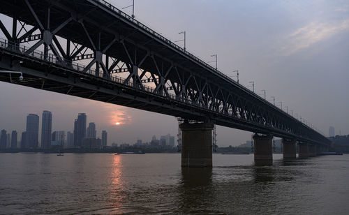 Low angle view of bridge over river in city