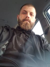 Portrait of young man sitting in car