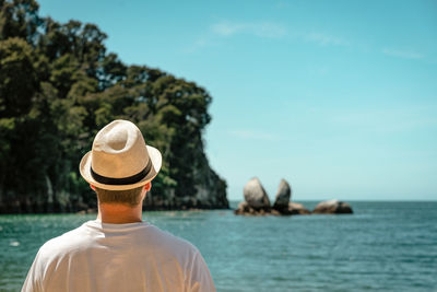 Rear view of man looking at sea against sky