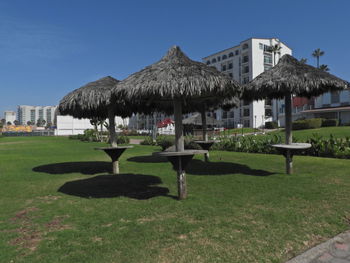 Lawn by building on field against clear sky