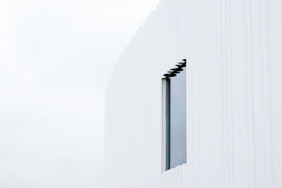 Low angle view of cross on building against white background