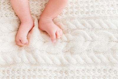 Baby's feet on white knitted background. little child's bare feet. cozy morning at home. 