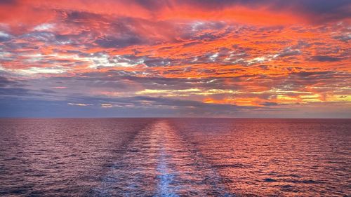 Scenic view of sea against dramatic sky during sunset