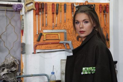 Portrait of woman standing against wall
