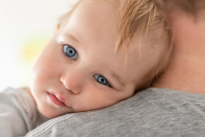 Baby leaning on shoulder of father