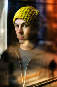 Portrait of young man seen through glass