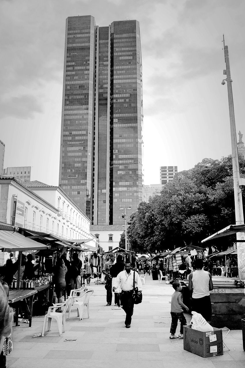 building exterior, architecture, built structure, city, large group of people, men, person, city life, lifestyles, sky, leisure activity, skyscraper, modern, tall - high, tree, office building, walking, street, building