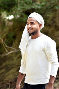 Smiling young man standing outdoors