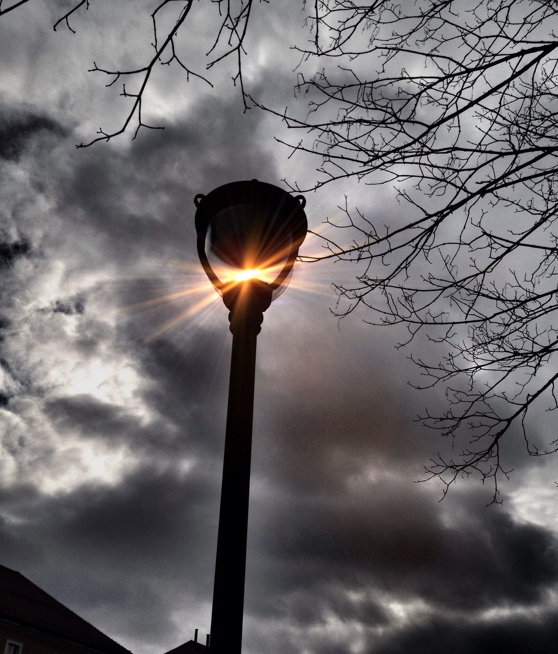 low angle view, sky, cloud - sky, silhouette, sun, cloudy, street light, tree, cloud, sunbeam, lighting equipment, nature, sunset, sunlight, tranquility, back lit, bare tree, outdoors, beauty in nature, no people