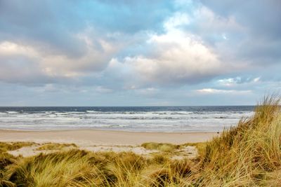 View of beach against cloudy sky