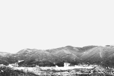 Scenic view of sea and mountains against clear sky