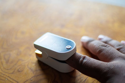 Close-up of person holding camera on table