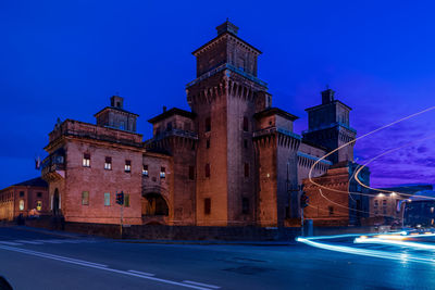 Illuminated building against blue sky at night