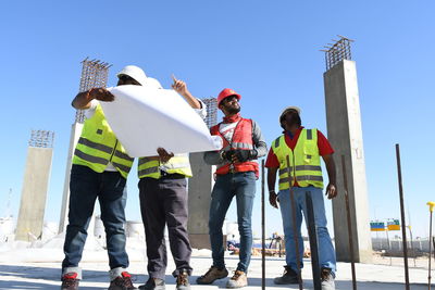 Low angle view of men working at construction site