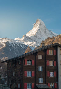 Houses against snowcapped mountains against clear sky