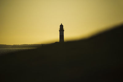 Silhouette of a maritime lighthouse against the sunset. 