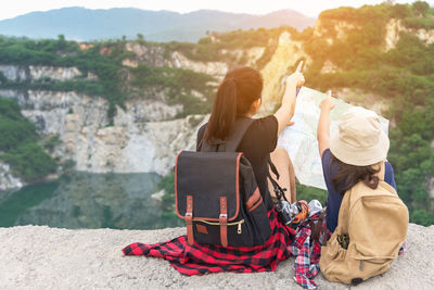 Rear view of couple sitting on mountain