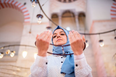 Woman in headscarf holding prayer beads