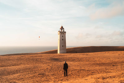 Lighthouse by sea against sky