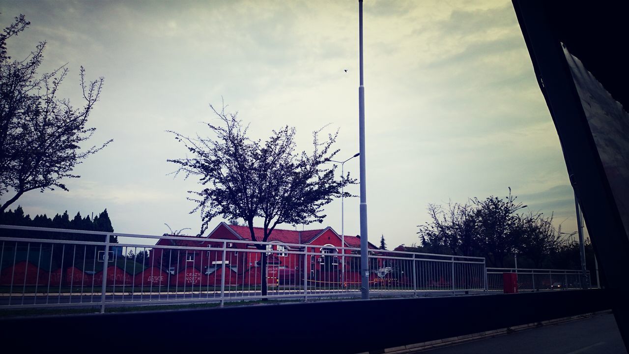 architecture, built structure, sky, building exterior, low angle view, tree, railing, cloud - sky, transportation, bridge - man made structure, cloud, connection, city, day, street light, building, outdoors, no people, cloudy, bare tree