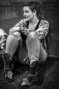 Woman sitting by metal grate