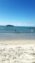 Scenic view of beach against clear blue sky