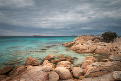 Rocks by sea against sky